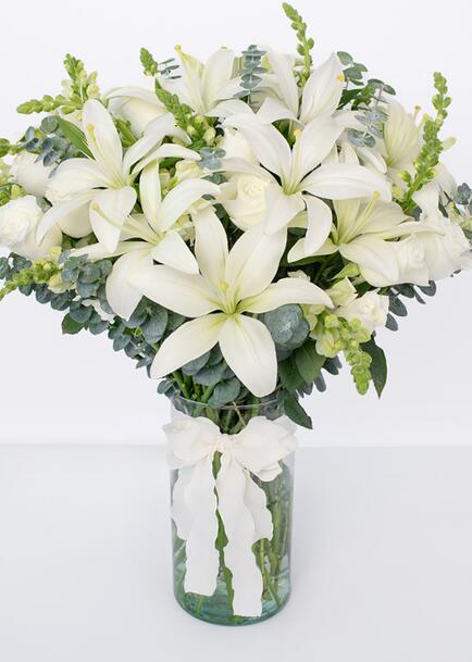 Rosas blancas y lilys blancas en jarrón cilindro